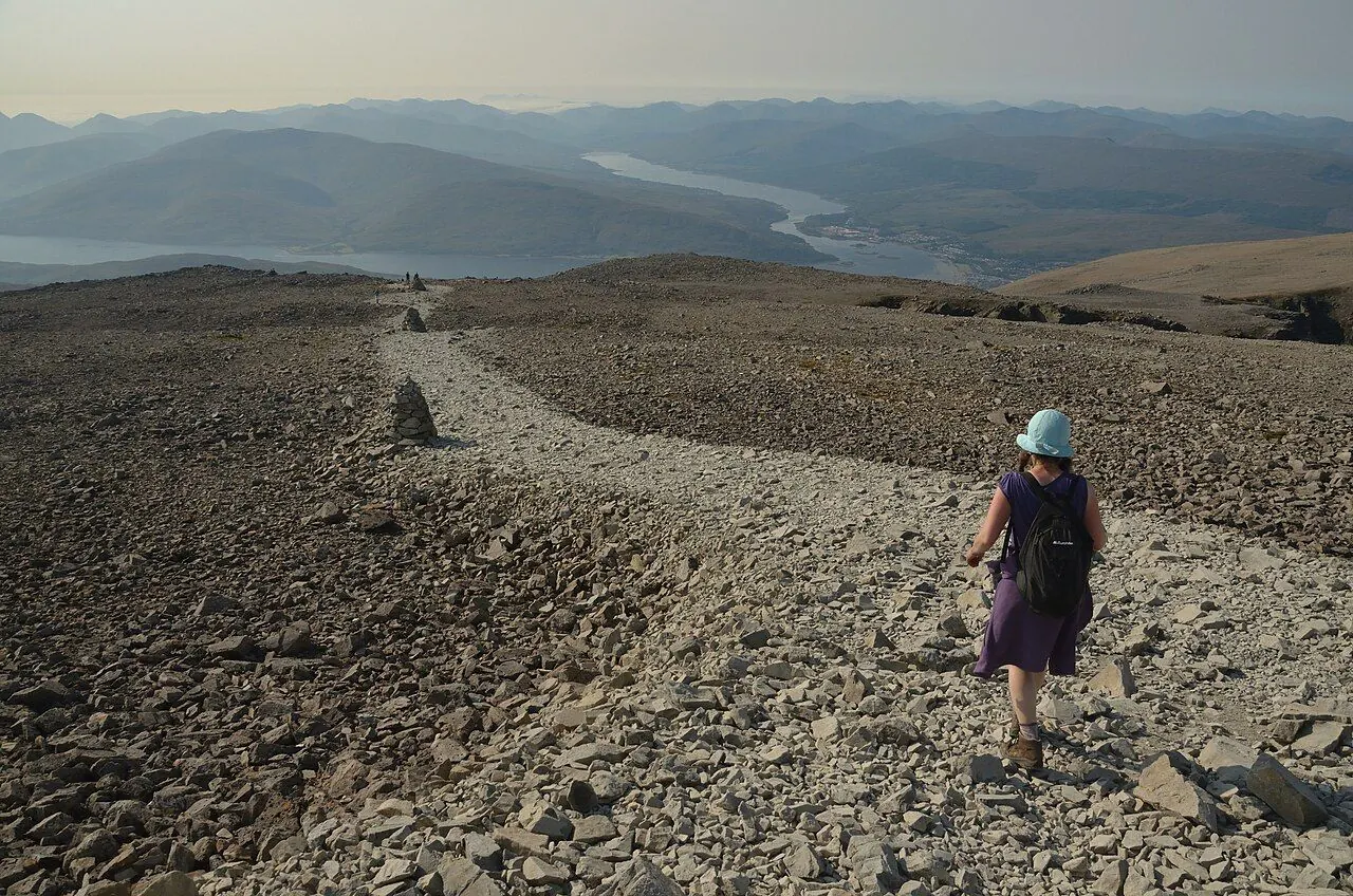 Walkers on a rocky mountain path above a valley